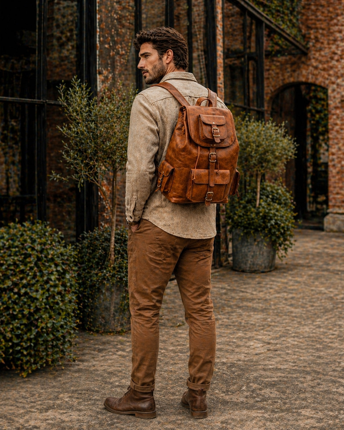 Man walking a city street wearing the DEKVIO brown leather travel backpack