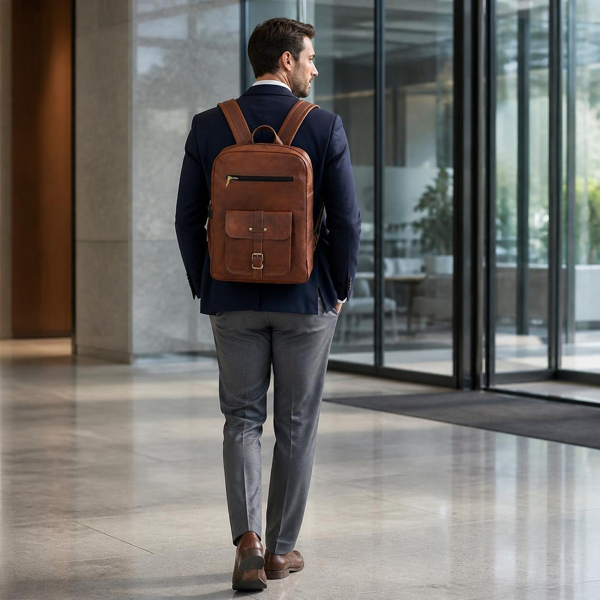 Man wearing the DEKVIO 18 inch brown leather square backpack in an office lobby