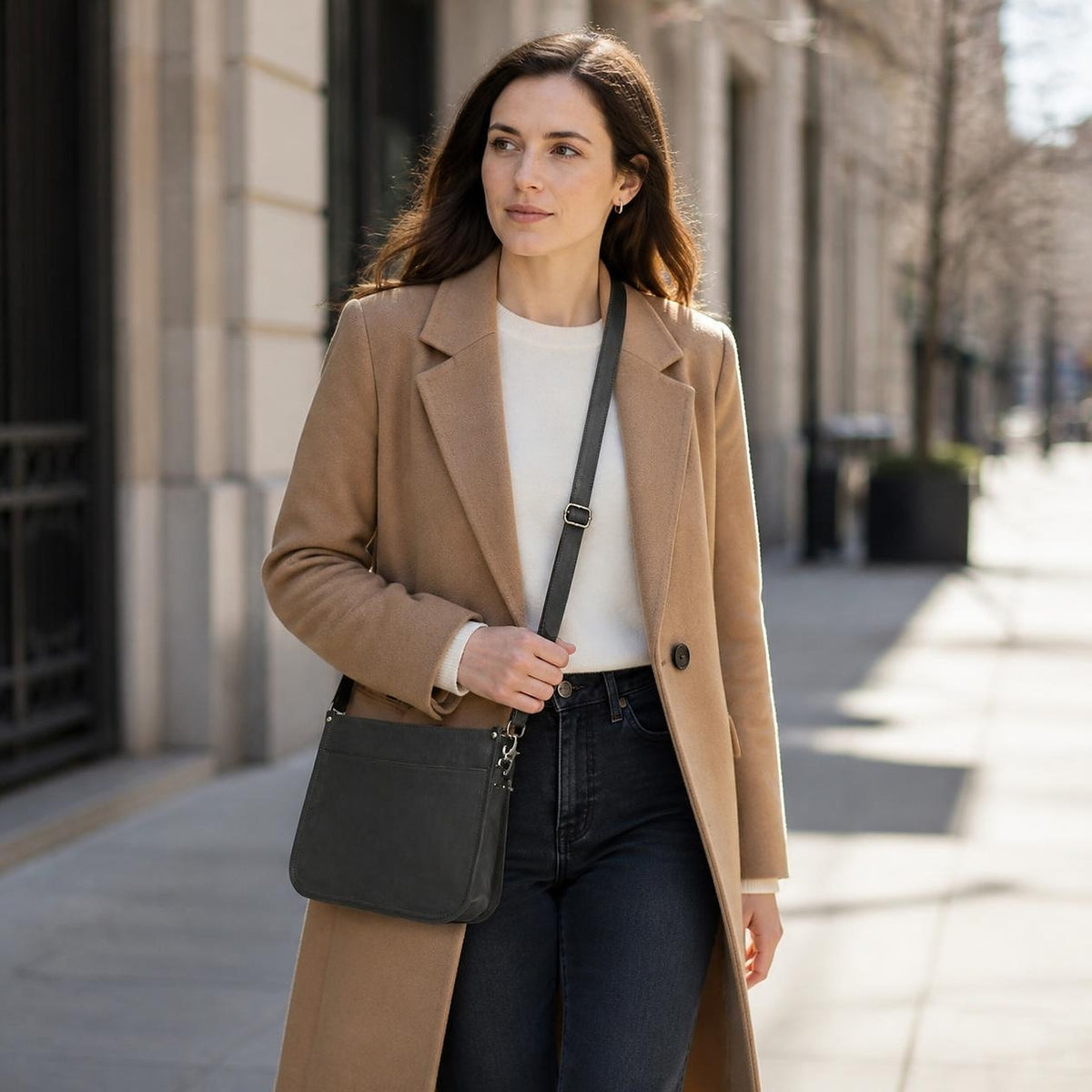 Woman wearing the DEKVIO black leather messenger crossbody bag on a street